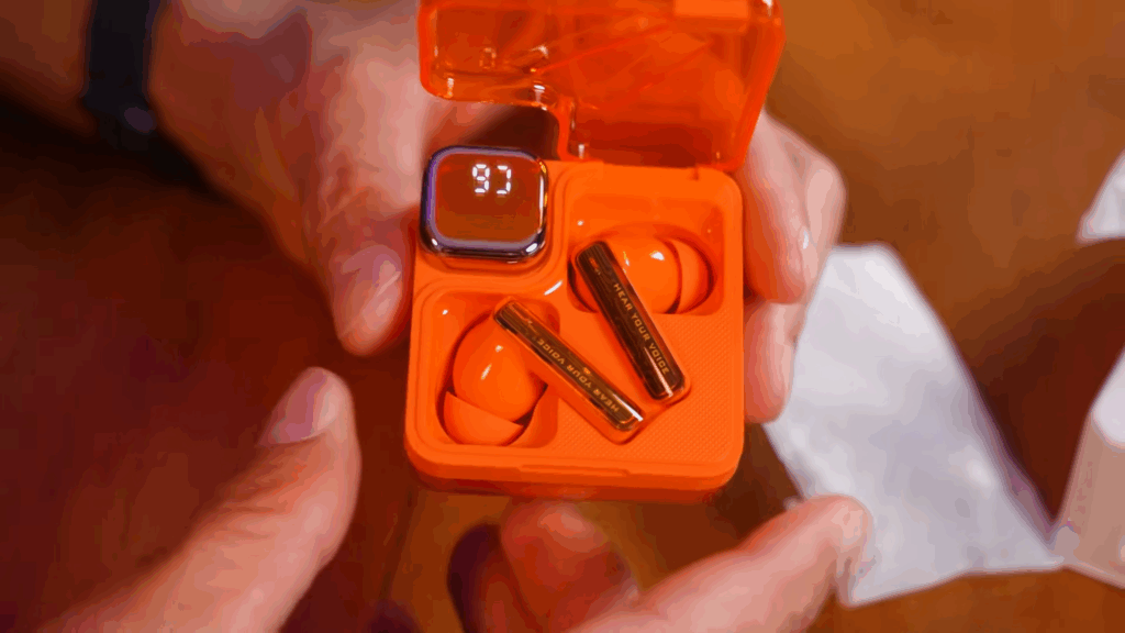 Fone de ouvido verdadeiro sem fio com estojo laranja vibrante, display digital e tecnologia avançada.