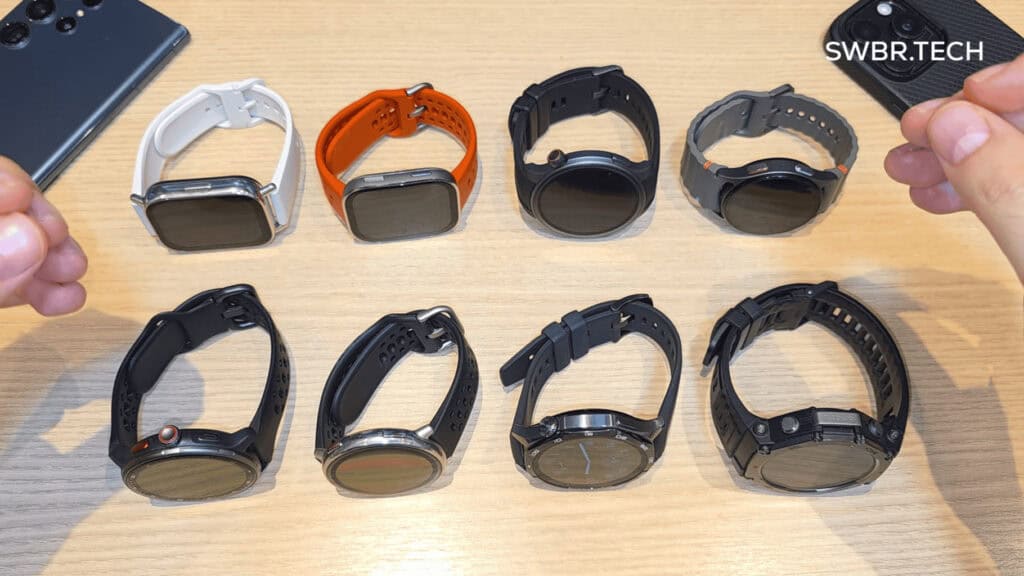 Relógios esportivos inteligentes de várias cores e modelos exibidos em mesa de madeira.